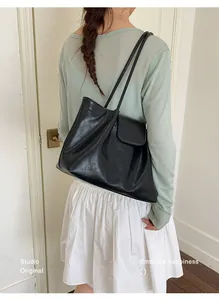 Model wearing the black pleated tote bag showing the side profile and strap length.