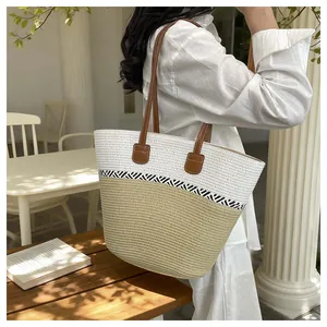 Handmade woven straw beach bag for women with leather straps in cafe setting