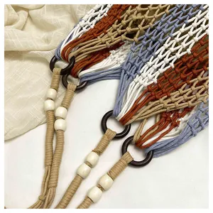 Close-up view of handmade macrame shoulder bag showing colorful woven patterns and beads