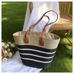 Large handmade striped straw beach tote bag for women in a summer garden setting