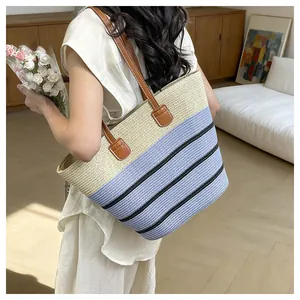 Handmade striped straw beach tote bag carried by a woman in a lifestyle setting
