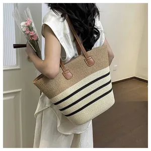 Handmade straw woven tote bag featuring black stripes and brown faux leather straps