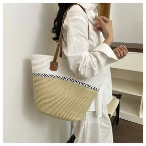 Stylish handmade woven straw tote bag for women shown on a model for summer beach