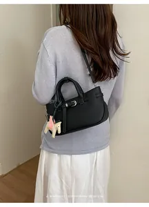 Sofisticata borsa tote in pelle nera da donna con grazioso ciondolo a cavallo stile minimal