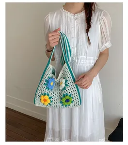 Detailed shot of a handmade knitted tote bag with colorful crochet flower decorations