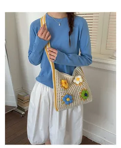 Detailed view of a handmade knit shoulder bag featuring vibrant 3D floral decorations.