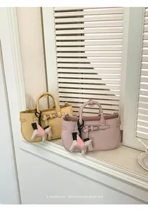 Primo piano di mini borse tote gialle e rosa con ciondoli a cavallo alato sul davanzale
