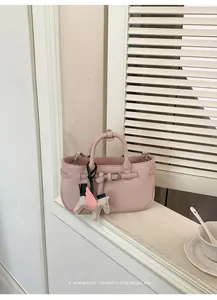 Elegante mini borsa rosa in pelle martellata con ciondolo decorativo a cavallo sul davanzale.