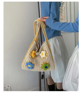 Close-up detail of a cream handmade crochet floral shoulder tote bag held by a model