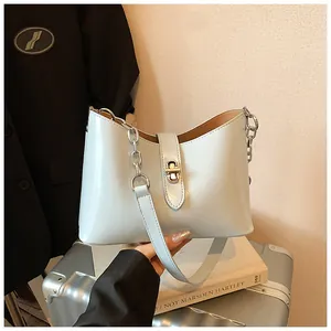 Elegante lichtblauwe okseltas met een gouden sluiting en veelzijdig kettingband detail