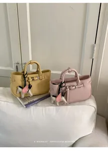 Vista dettagliata di due mini borse alla moda in giallo e rosa con ciondoli a cavallo