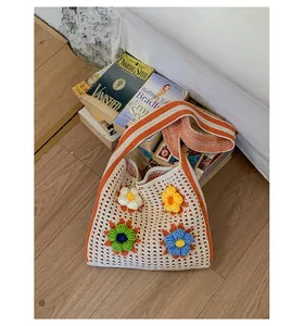 Close-up of handmade knitted tote bag with colorful crochet 3D flowers