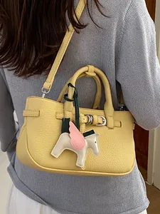 Elegante borsa a tracolla in pelle martellata gialla con un ciondolo a pegaso chic.