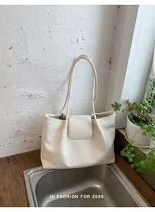 Elegant cream pleated tote bag with flap closure in a minimalist lifestyle setting
