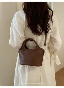 Vue détaillée d'un sac à main rétro en cuir marron porté par un mannequin en robe