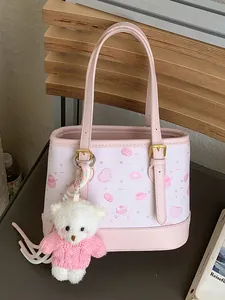 Chic pink bucket bag featuring cartoon prints and a cute plush teddy bear charm
