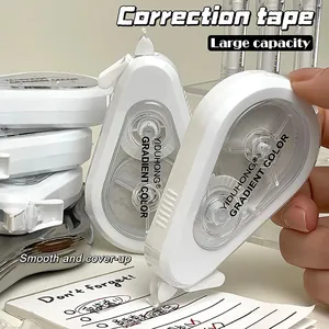 Close-up of white ergonomic correction tape being used on a lined notebook page