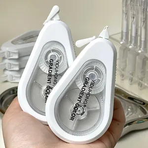 Close-up of white flip-top correction tape dispensers with YIDUHONG brand engraving