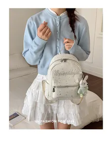Primer plano de mochila de lona blanca con patrones de estrellas y peluche suave