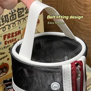 Gros plan de la poignée de transport sur une trousse à crayons en maille.