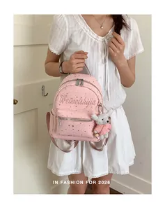 Vista detallada de mochila rosa con diseño de estrellas y un lindo llavero de conejito