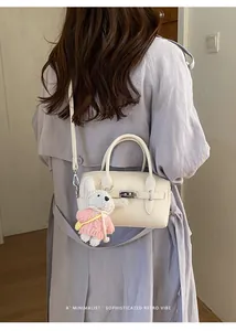 Minimalist off-white lychee pattern bowling bag with a cute rabbit plush doll charm
