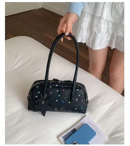 Detalle del bolso de almohada negro para mujer con estampados de estrellas de colores