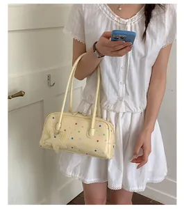 Detalle de estilo de vida de un bolso tipo almohada crema con estrellas de colores