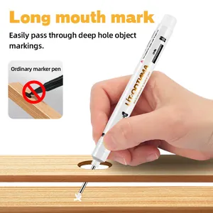 Detailed view of white long-nib marker pen marking a deep hole on wooden surface