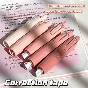 Dettaglio del nastro correttore a pressione sfumato su un taccuino rosa scritto