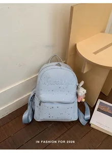 Mochila de moda azul claro con patrones de estrellas plateadas y colgante de conejo