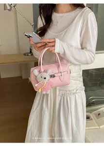 Model holding a pink lychee pattern bowling bag with a cute rabbit charm in a cozy room