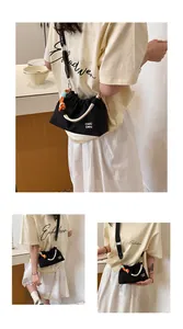 Mini sac bandoulière décontracté en nylon noir avec poignée en corde colorée sur modèle.