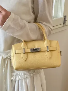 Elegant yellow pebbled leather bowling bag with classic turn-lock closure and top handles