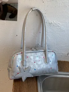 Bolso de hombro plateado metalizado con estrellas de colores y colgante de estrella