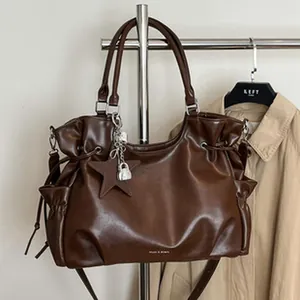 Brown faux leather underarm bag with pleated design and star charm pendant detail