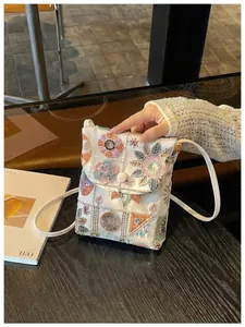 Dettaglio della borsa a tracolla ricamata stile cinese con motivi floreali eleganti.