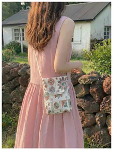Dettaglio di una borsa a tracolla ricamata a mano in stile cinese moderno su modella