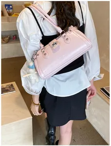 Élégant sac à bandoulière rose rétro avec breloque en peluche dans un décor lifestyle