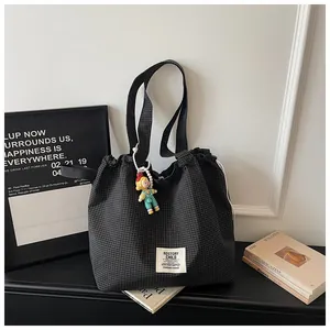 Detail of large capacity black checkered canvas tote bag with drawstring closure