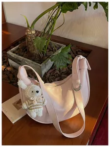 Chic pink dumpling style crossbody bag with a cute handmade crochet rabbit charm detail