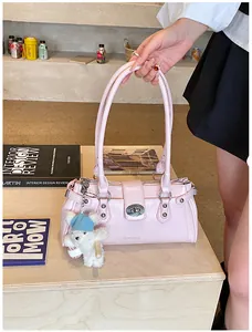Gros plan d'un sac à bandoulière vintage rose avec un joli charm d'ours sur une table