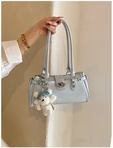 Vue détaillée d'un sac à bandoulière vintage bleu clair brillant avec porte-clé ours