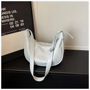 Minimalist light blue crescent dumpling bag for women shown from a stylish side angle.