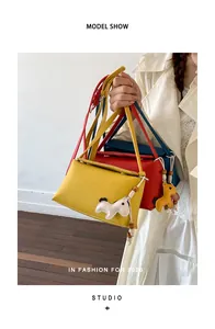 Modella con tre borse a tracolla quadrate coreane minimaliste in giallo, rosso e blu