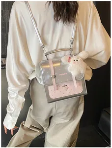 Silver metallic Korean style backpack with pink polka dots and plush bunny charm worn by a model