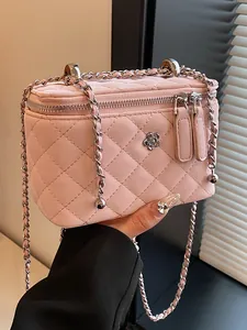 Elegant pink quilted vanity box handbag with camellia logo and silver woven chain strap