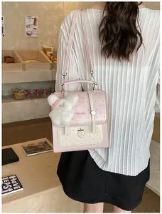 Detail view of a stylish pink polka dot backpack for women with a cute plush bunny keychain.