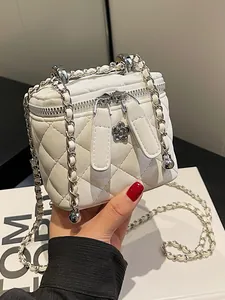 Elegant white quilted box bag with silver chain strap and camellia floral charm