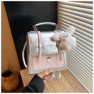 Close-up detail of silver polka dot backpack with plush bunny keychain accessory